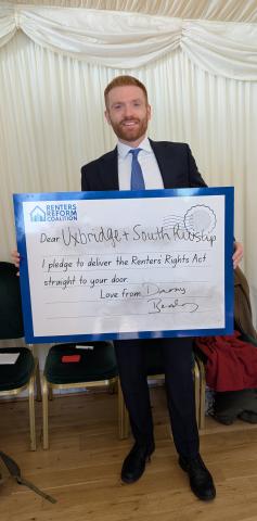 MP Danny Beales holding a postcard reading "Dear Uxbridge + South Ruislip, I pledge to deliver the Renters' Rights Act straight to your door. Love from Danny Beales"